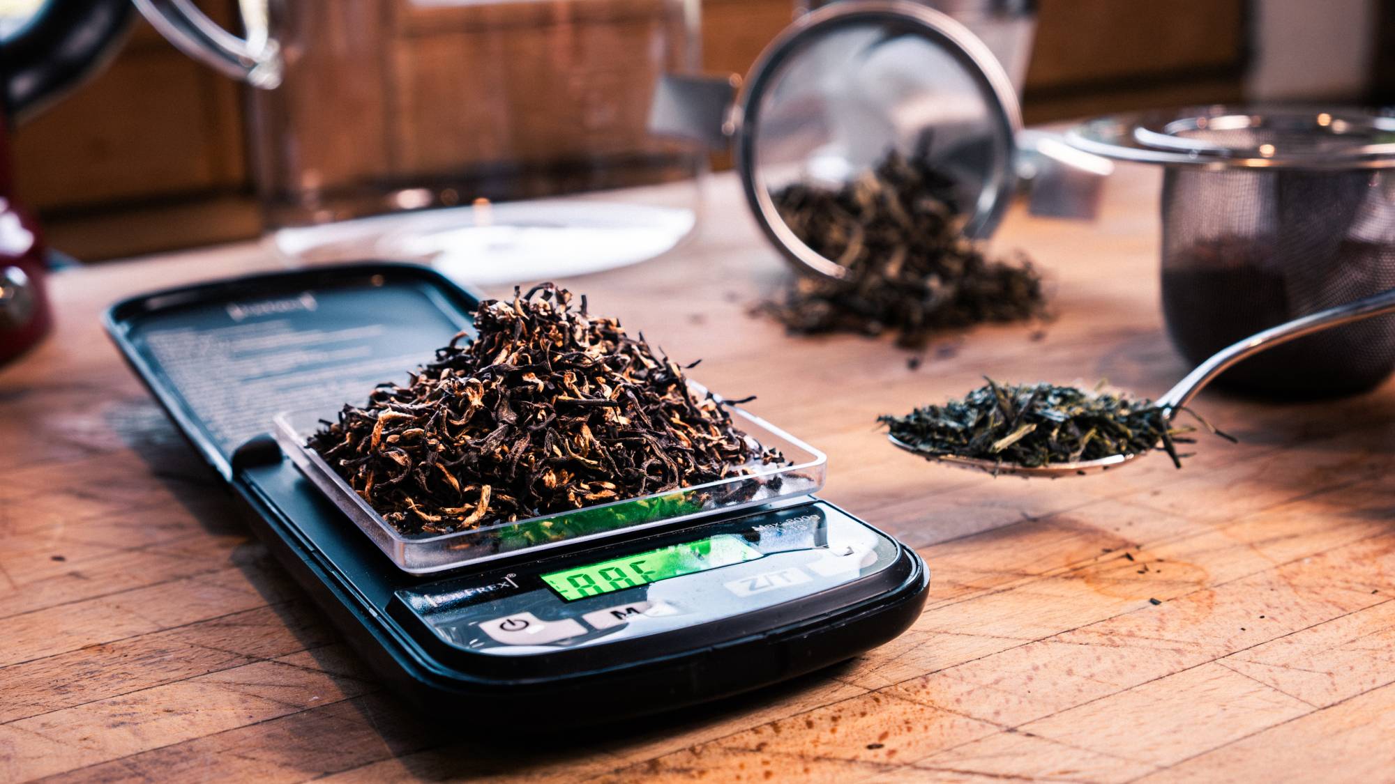Du thé dans un cuillère et sur une petite balance.